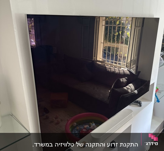 טלוויזיה תלויה על קיר עם שלטים ומערכת שמע